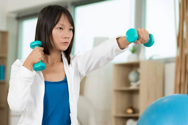 Serious Young Woman Holding Dumbells Indoor — 스톡 사진