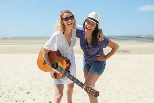 Two Jovial Women Beach Holding Guitar Obraz Stockowy