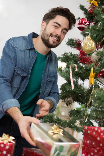 Man Putting Gifts Christmas Tree — ストック写真