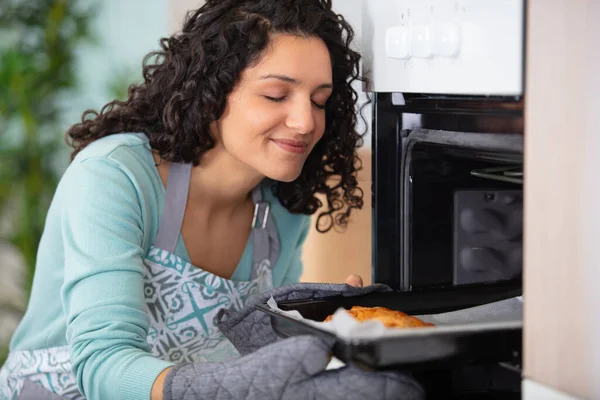 Brunette Taking Food Out Oven — Photo