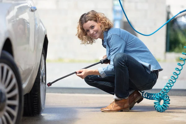 Νεαρή Γυναίκα Πλένει Αυτοκίνητό Της Χρησιμοποιώντας Νερό Υψηλής Πίεσης — Φωτογραφία Αρχείου