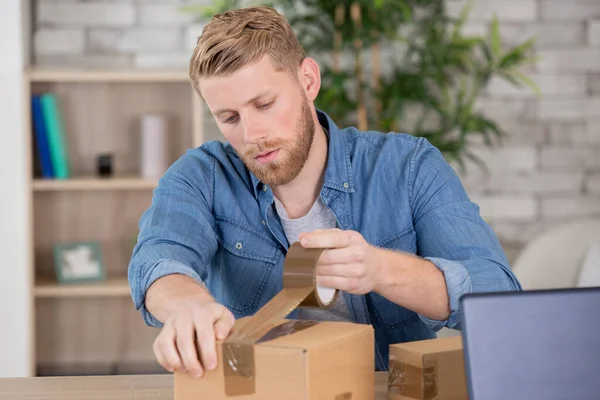 Man Wrapping Box While Moving Home — 스톡 사진