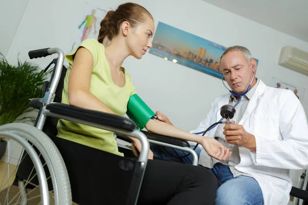 Doctor Takes Tanometrom Pressure Female Patient Wheelchair — Stock Photo, Image