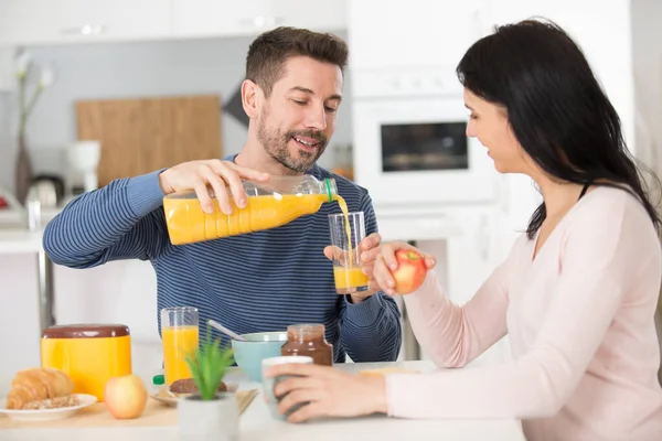 Ζευγάρι Στην Αγάπη Ρίχνει Χυμό Πορτοκάλι Στο Πρωινό — Φωτογραφία Αρχείου