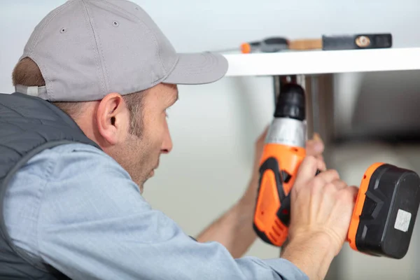 Man Holding Drill Repairing Kitchen Sink Home — Foto de Stock