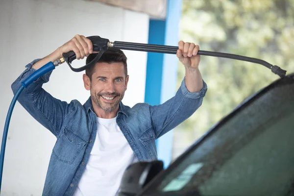 男子在洗他的车在自助服务汽车清洗站 — 图库照片