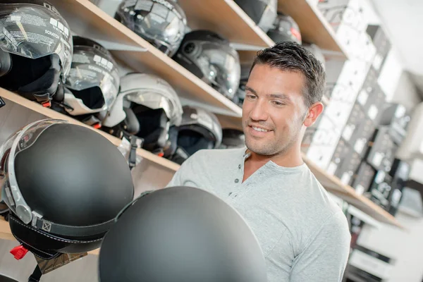Man Comparing Two Helmets — Photo