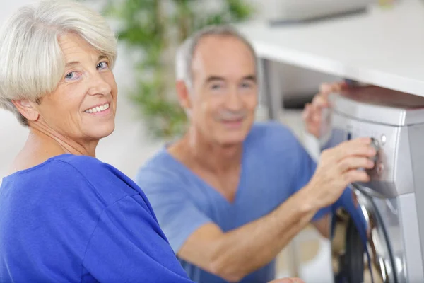 Senior Couple Using Washing Machine — Stockfoto
