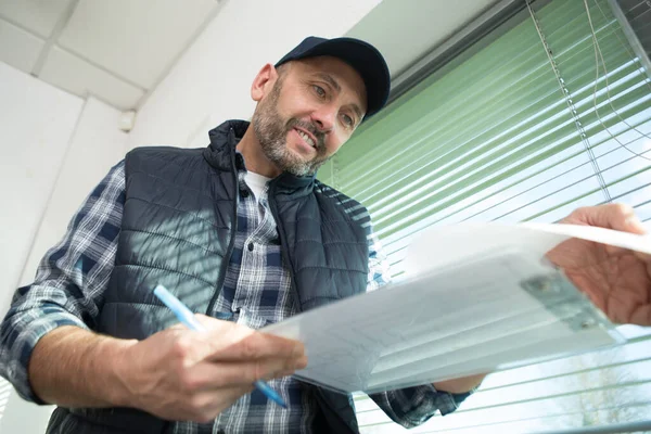 Mature Male Contractor Looking Paperwork His Clipboard — Stockfoto