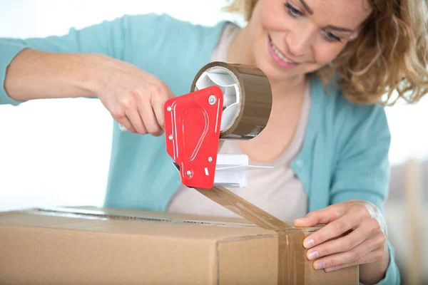 Woman Sealing Cardboard Box Tape — Stockfoto