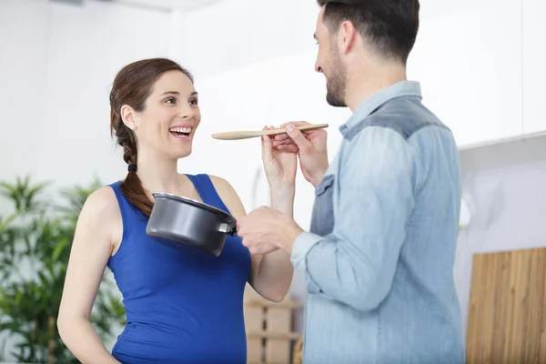 Pregnant Woman Tasting Food Her Partner Has Prepared — Zdjęcie stockowe