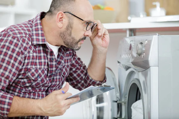 Serviceman Putting Eyeglasses Look Washing Machine —  Fotos de Stock