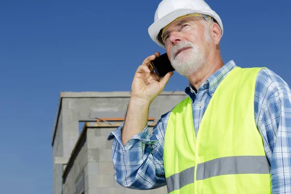 Mature Builder Using Telephone Property Construction Stock Picture