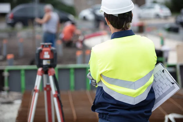 rear view of land surveyor working with theodolite