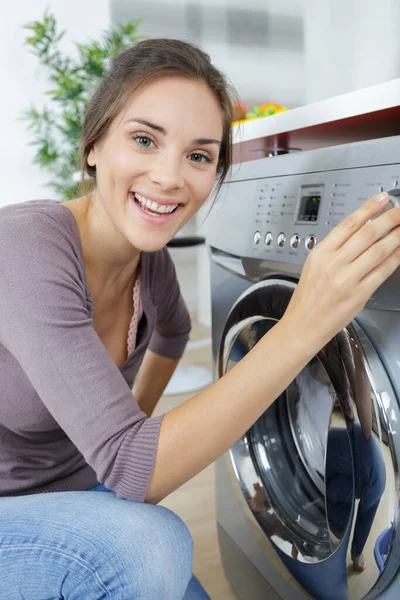 woman using washing machine at home