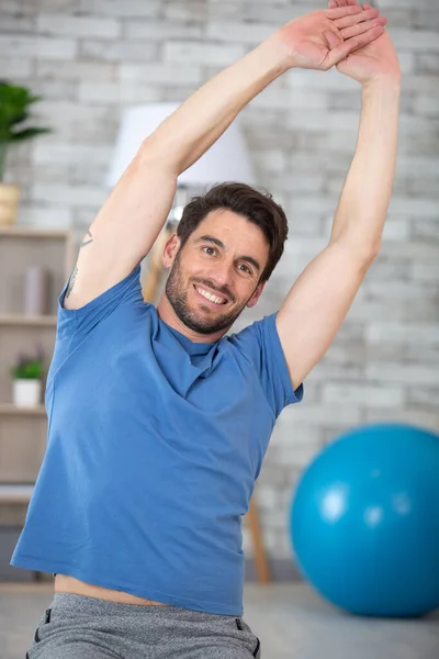 man exercising with arms raised above his head