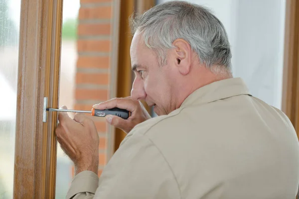 senior man fitting a window