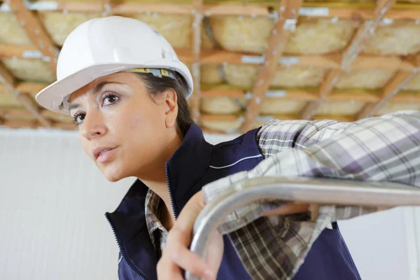Frau Mit Kuriosem Gesichtsausdruck Bauarbeiteruniform Auf Leiter Drinnen — Stockfoto