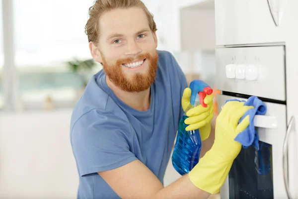 厨房里打扫家用烤箱的男人 — 图库照片