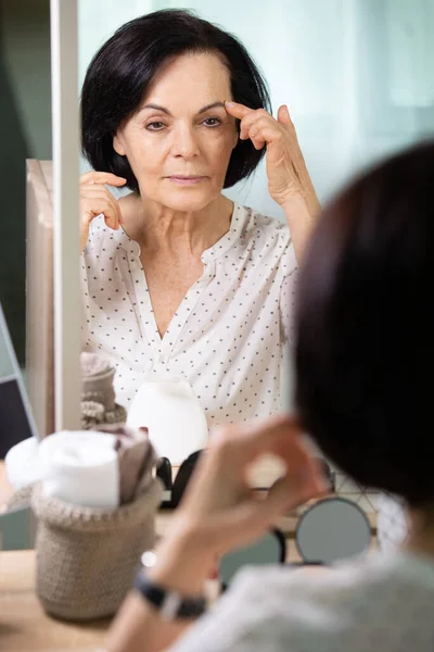 Bella Donna Anziana Utilizzando Crema Davanti Allo Specchio — Foto Stock