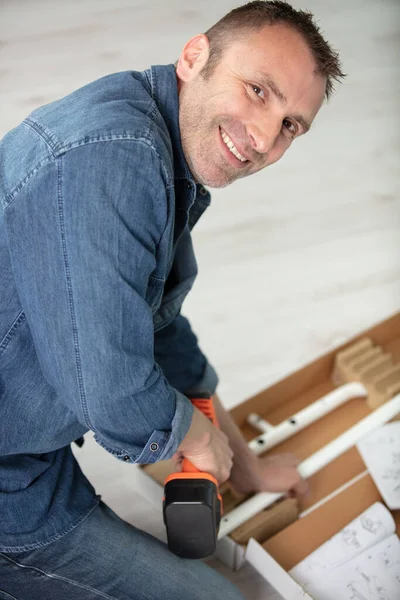 Ευτυχισμένος Άνθρωπος Βάζοντας Ξύλινο Ράφι Στο Σπίτι — Φωτογραφία Αρχείου