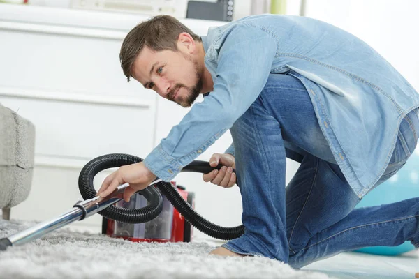 Hombre Aspirando Suelo Debajo Sofá —  Fotos de Stock