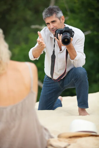 Fotograf Führt Seniorin Strand Zum Shooting — Stockfoto