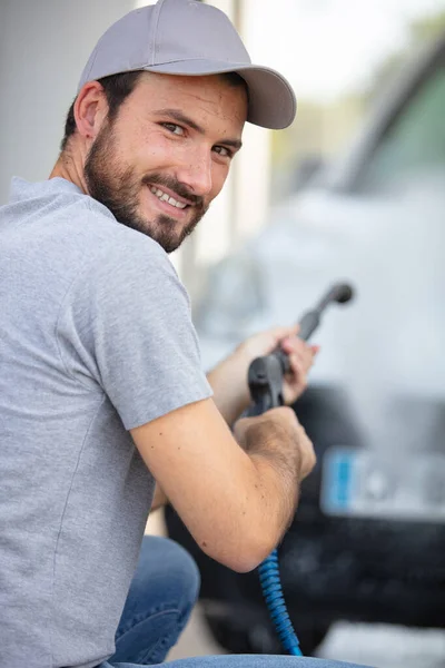 Man Schoonmaken Auto Met Een Spuit Rechtenvrije Stockafbeeldingen