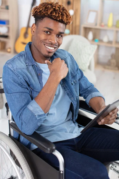 Tekerlekli Sandalyedeki Genç Adam Beyaz Üzerinde Izole Tablet Kullanarak — Stok fotoğraf