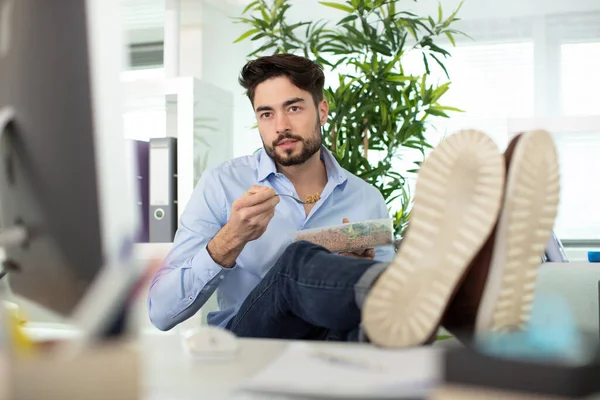 thoughtful man sitting with feet on table in office