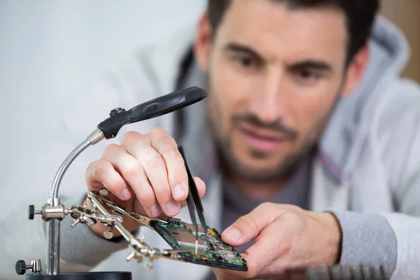 electronics repair service technician disassembling smartphone for inspecting