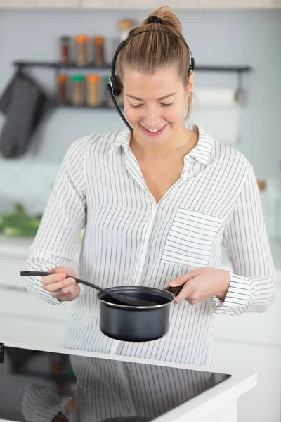 young woman cooking in modern kitchen and working
