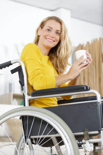 車椅子の若い女性がコーヒーを飲み — ストック写真