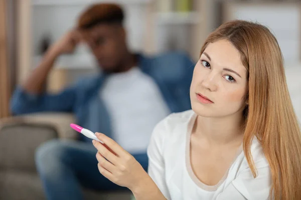 stressed couple doing pregnancy test at home