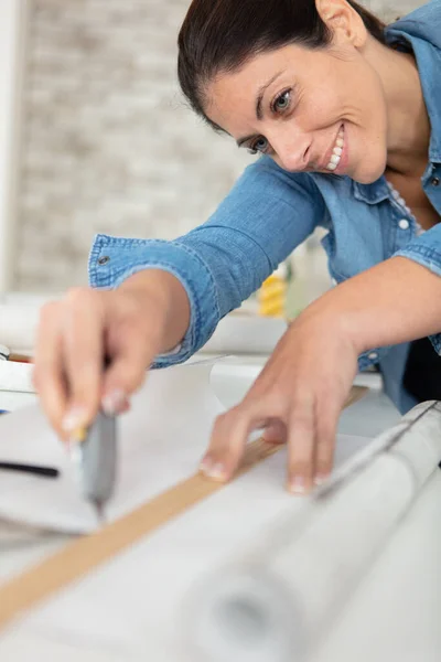 Frau Schneidet Tapete Mit Einem Cutter — Stockfoto