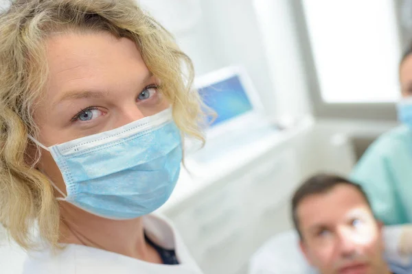 カメラ歯科医院を見るマスクの歯科医の肖像画 — ストック写真