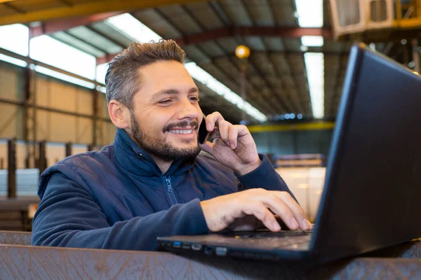Pracownik Fabryki Korzystający Laptopa Rozmawiający Przez Telefon — Zdjęcie stockowe