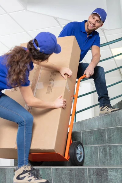 Vrouwelijke Mannelijke Verhuizers Met Een Grote Kartonnen Doos — Stockfoto