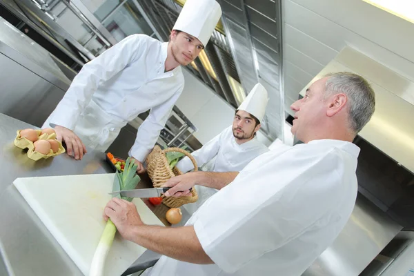 Chef Conversando Com Estagiários Enquanto Demonstração Como Cortar Alho Porro — Fotografia de Stock