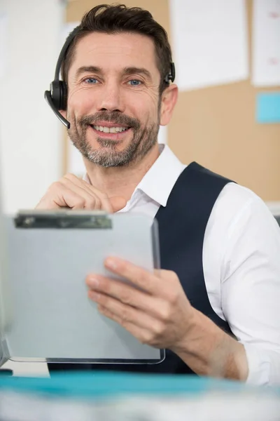 Homem Sorrindo Usando Fone Ouvido Segurando Uma Área Transferência — Fotografia de Stock