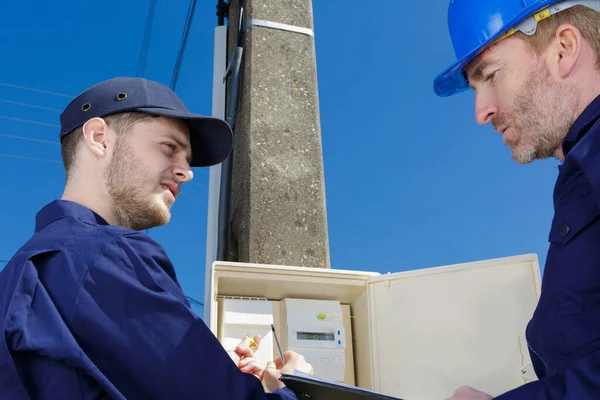 Deux Techniciens Masculins Regardant Compteur Électrique Extérieur — Photo