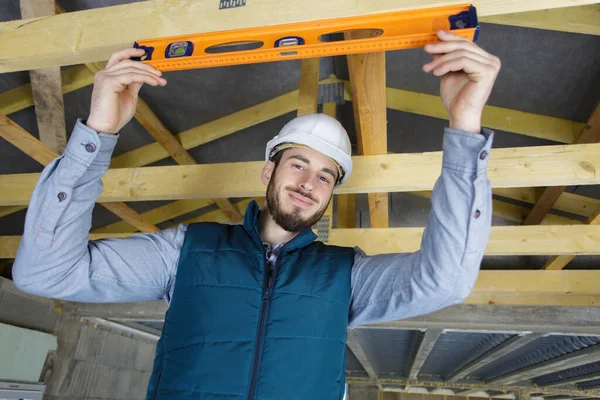 Pracovník Kontroluje Úroveň Dřevěné Konstrukce Domu — Stock fotografie