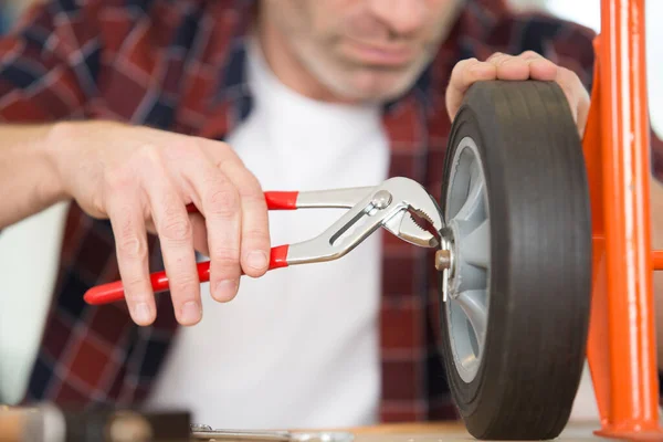 Immagine Ritagliata Del Lavoratore Che Fissa Una Ruota Del Carrello — Foto Stock