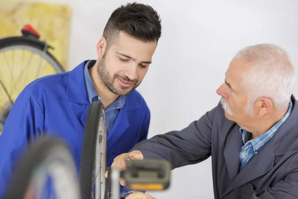 Lavoratore Anziano Che Mostra All Apprendista Come Riparare Una Bici — Foto Stock