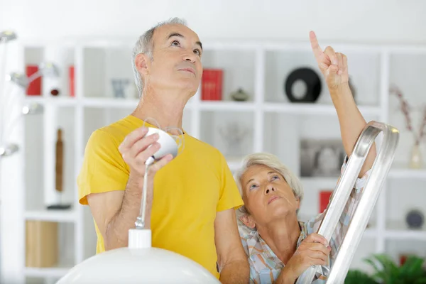 Senior Man Doet Thuis Reparatie Lamp — Stockfoto