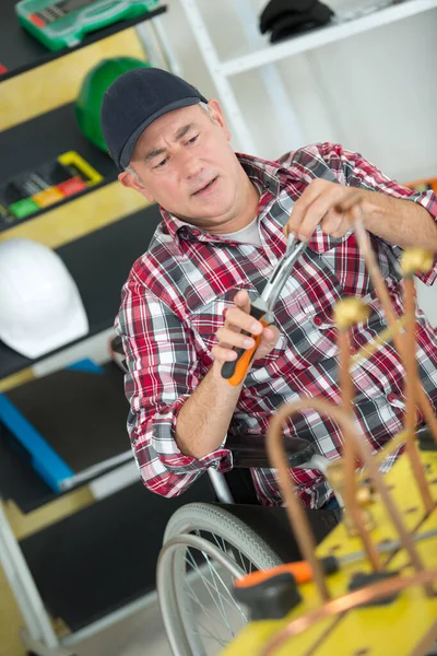 Rollstuhlfahrer Fixiert Kupferrohre — Stockfoto