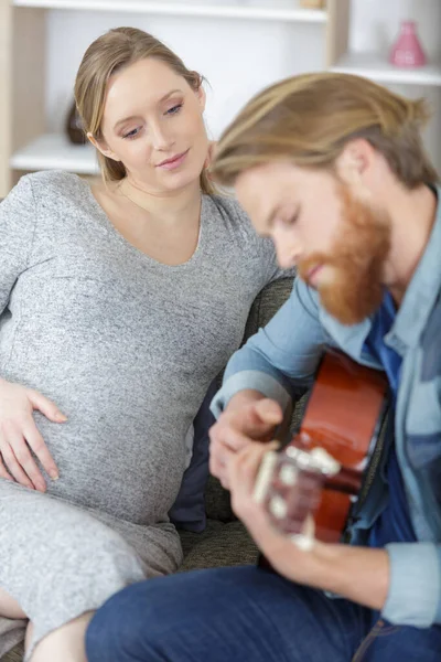 快乐的怀孕年轻夫妇享受音乐 — 图库照片