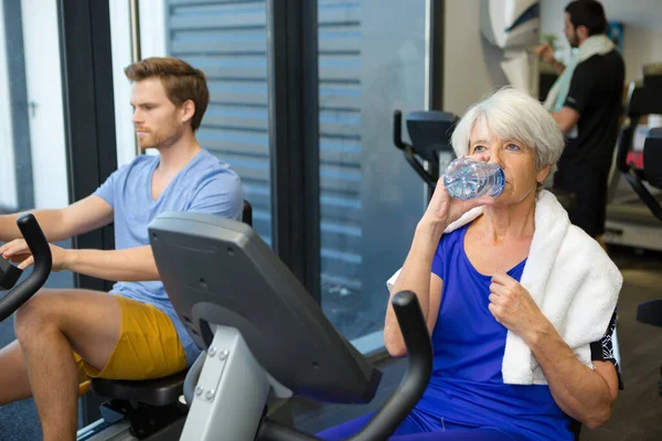 Seniorin Fitnessstudio Trinkt Wasser — Stockfoto