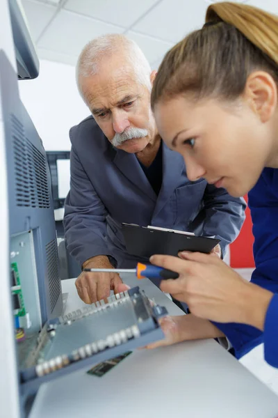 Technik Praktykanta Śrubokrętem Pracującym Nad Urządzeniem Elektrycznym — Zdjęcie stockowe