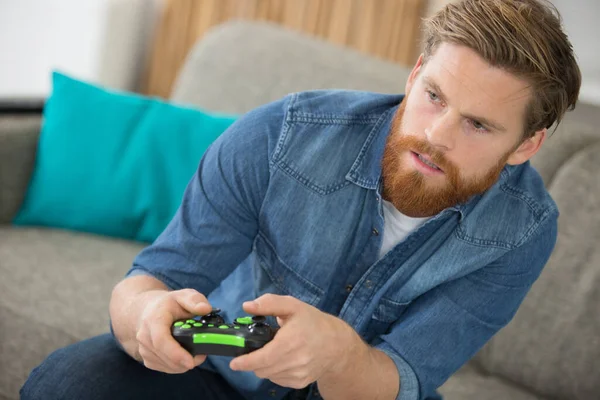 Knappe Man Zittend Een Bank Videospelletjes Spelend — Stockfoto